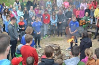Rádcové zapalují slavnostní táborový oheň.